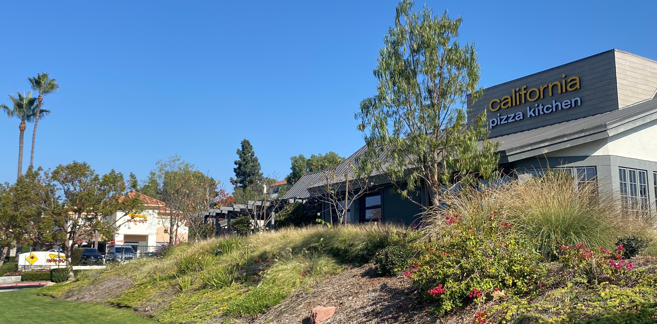 Exterior photo of California Pizza Kitchen and In-N-Out store front sign at Village La Paz, Laguna Niguel, CA